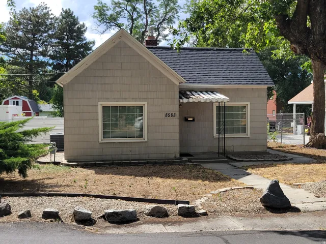 Gable roofline with shingle siding, covered entry with awning, and front walkway