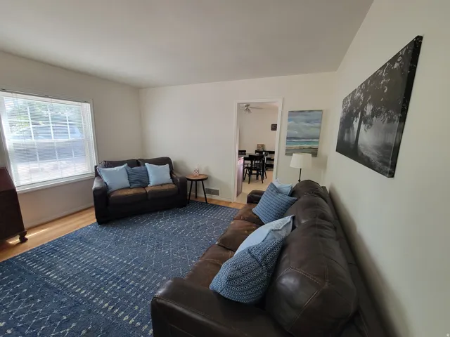 Bright living area featuring light-toned walls and wood-finish flooring