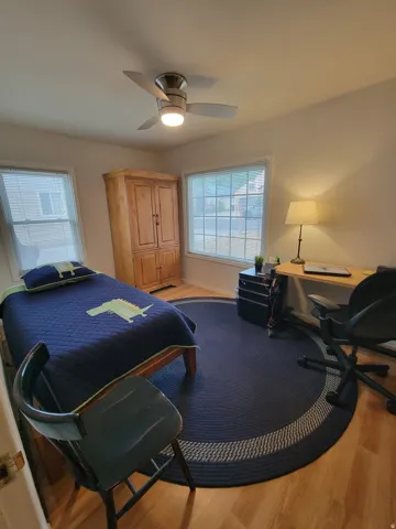 Recessed ceiling fan with integrated lighting, wood-finish flooring, and two windows providing natural illumination