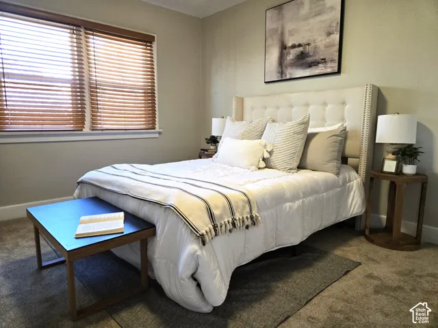 Neutral-toned room featuring wall-to-wall carpeting and horizontal window blinds