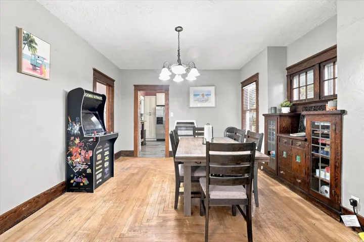 Hardwood flooring, wood trim, built-in cabinetry, and a chandelier
