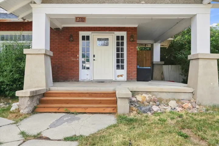 Brick facade with a covered porch featuring white columns