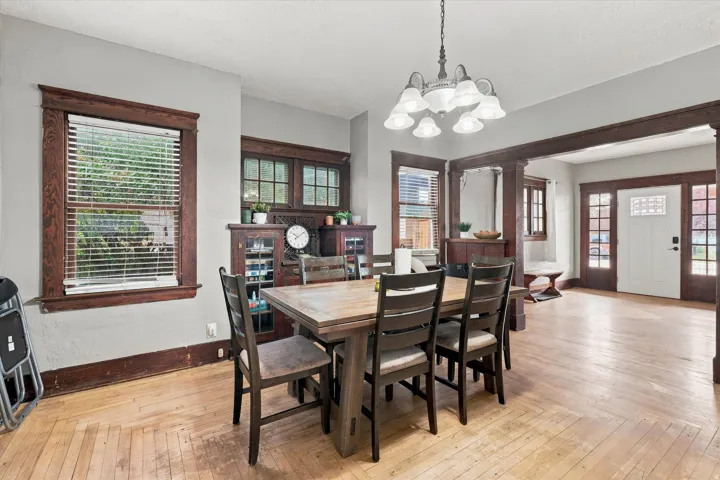 Light wood-finish flooring, built-in wooden cabinetry, recessed window, and a decorative ceiling fixture