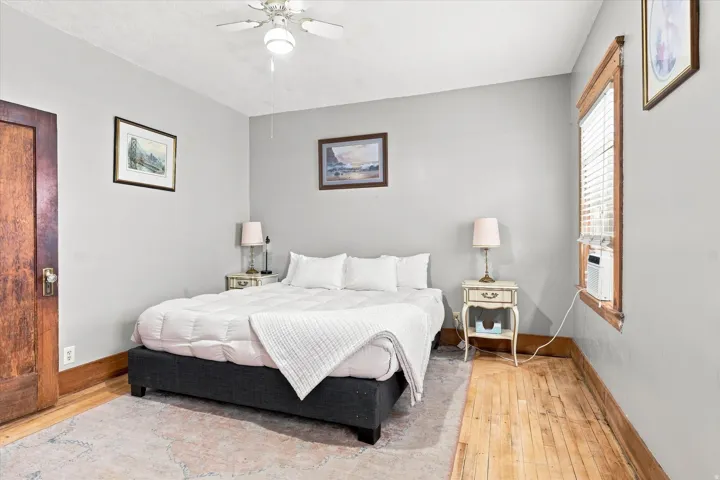 Wood-finish flooring, ceiling fan, and window with blinds