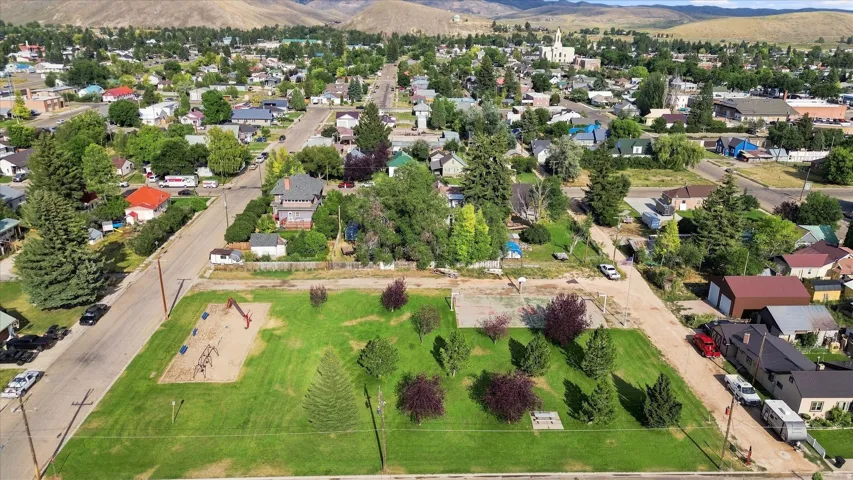 Expansive grounds featuring mature landscaping with mixed tree plantings, manicured lawn areas, and defined hardscaped sections