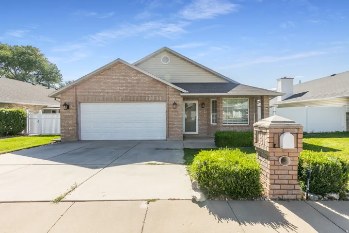 Brick exterior with an attached garage, covered front entry, and a prominent brick mailbox