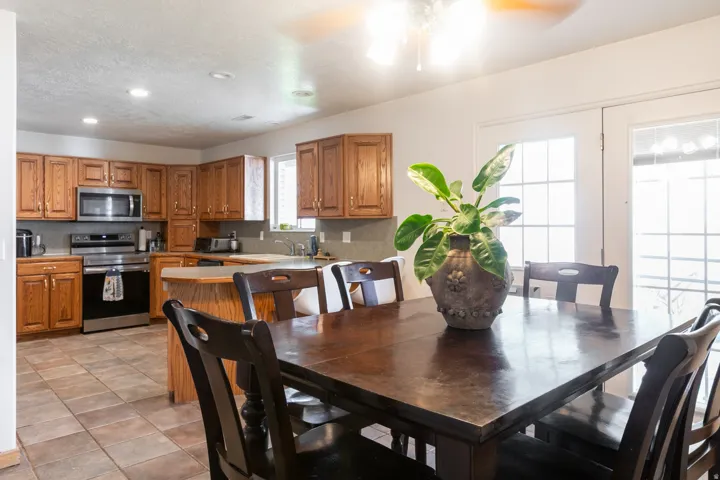 Kitchen area featuring wood cabinetry, stainless steel appliances, and a tiled floor