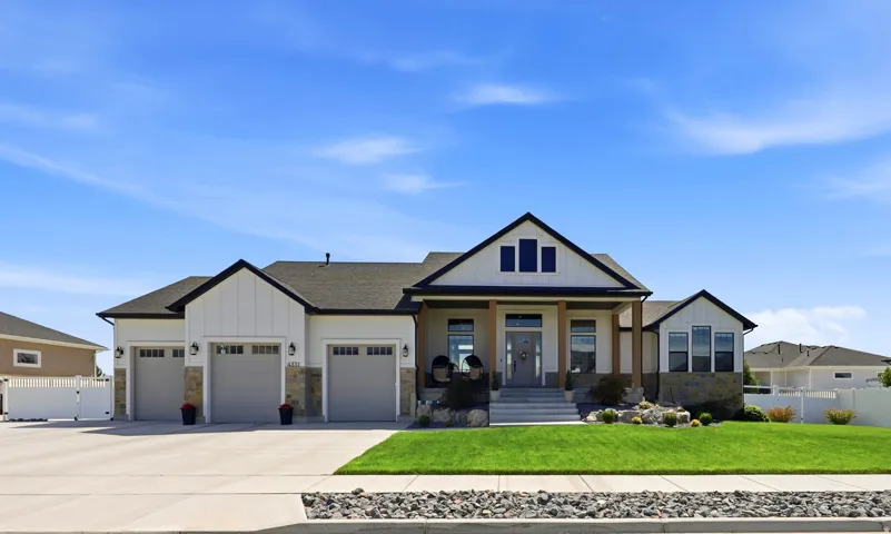 Craftsman-style exterior with a covered porch, stone accents, and a three-car garage