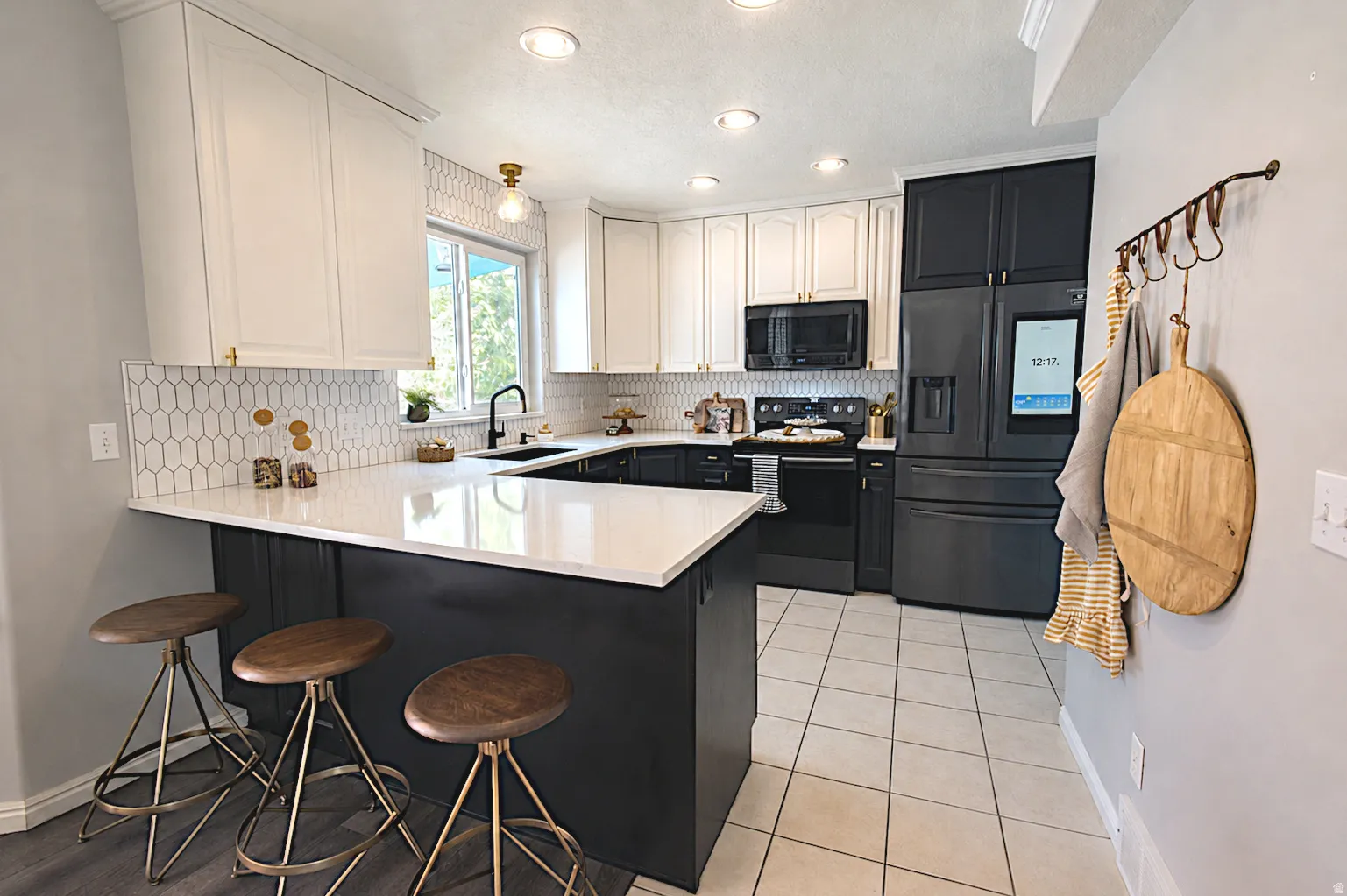 White shaker cabinetry, black base cabinetry, white countertop, white backsplash, and recessed lighting
