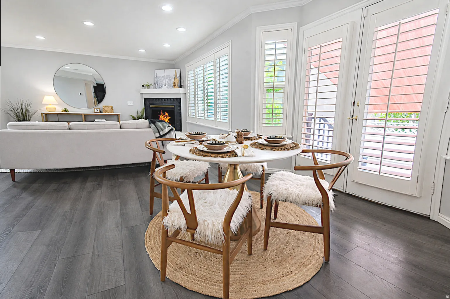 Wood-finish flooring throughout, fireplace with mantel, window shutters, recessed lighting, and patio doors