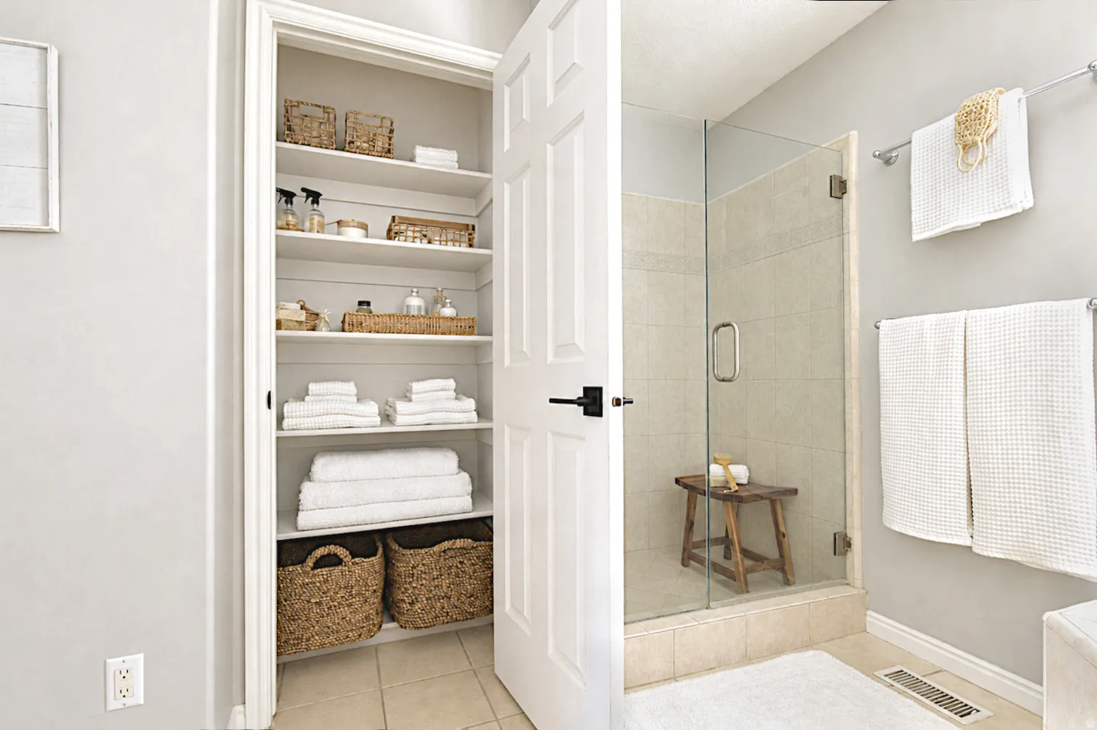 Walk-in shower with clear glass enclosure, tiled walls, and a tiled floor