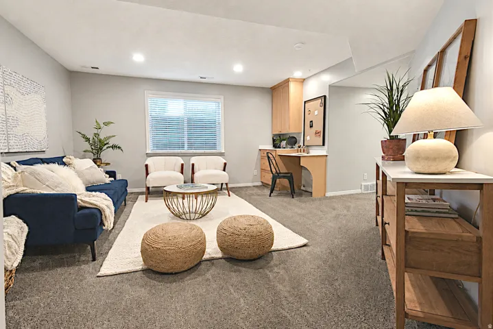 Recessed lighting, built-in desk, wood-finish cabinetry, and window with horizontal blinds