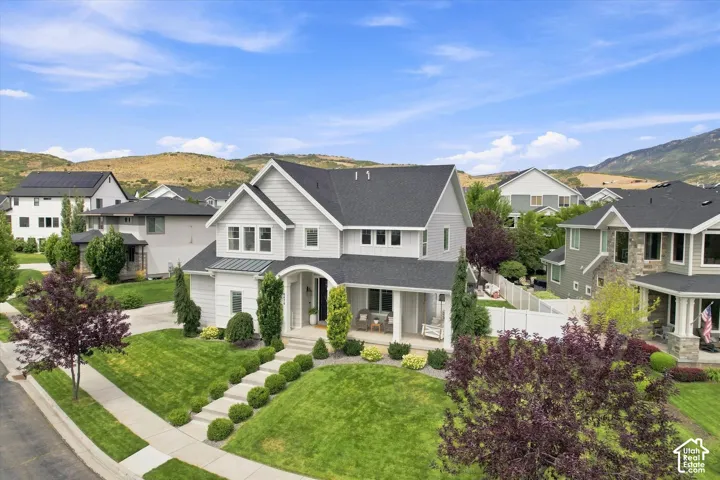 Contemporary two-story residence with a covered front porch, gabled roof, and a terraced front lawn