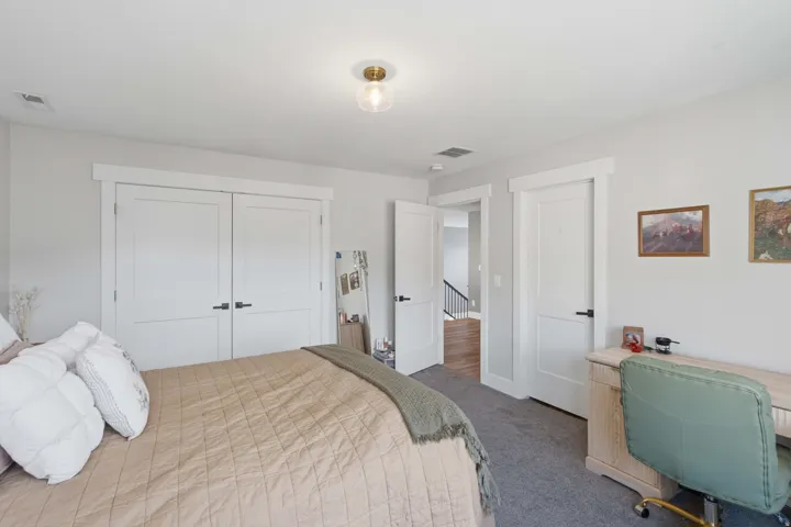 White interior doors with matte black hardware, recessed lighting, and a contemporary flush-mount ceiling fixture