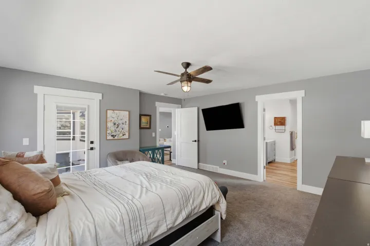 French doors with transom window, ceiling fan with integrated lighting, wall-mounted television, and wood-finish flooring