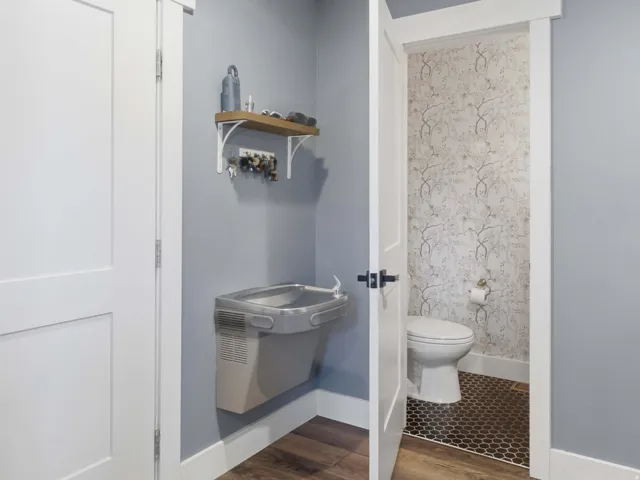 Water fountain located adjacent to garage, mudroom, and the guest bathroom