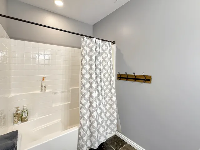 Spacious ensuite primary bath with double vanity, gorgeous granite countertops, and knotty alder cabinets.