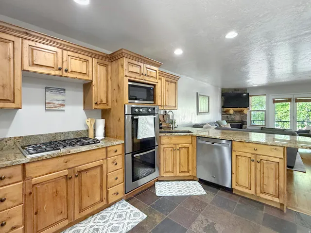 Sold fully furnished and turn-key, open concept kitchen, dining, and living area. Kitchen has knotty alder cabinets, beautiful granite counters, double oven, gas countertop stove, and stainless steel appliances.