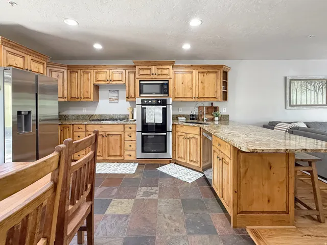 Sold fully furnished and turn-key, open concept kitchen, dining, and living area. Kitchen has knotty alder cabinets, beautiful granite counters, double oven, gas countertop stove, and stainless steel appliances.
