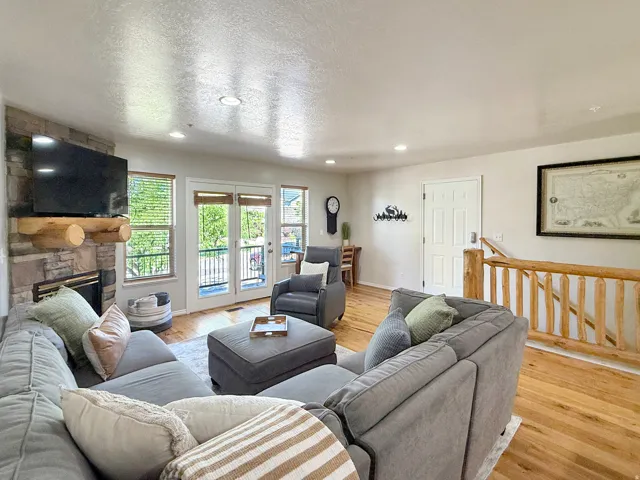 Sold fully furnished and turn-key, open concept kitchen, dining, and living area with real hardwood floors, stone gas log fireplace, and access to the front deck with beautiful mountain views and sunsets.