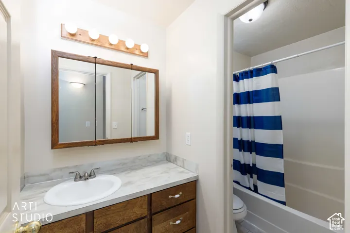 Vanity with a built-in sink, wood-finish cabinetry, and a countertop