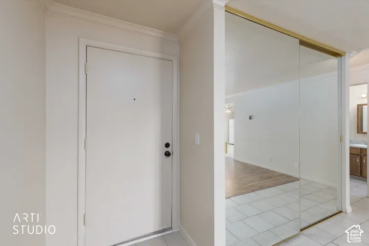 Entryway featuring crown molding and mirrored sliding closet doors