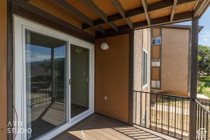 Private balcony with wood-finish decking and dark metal railings