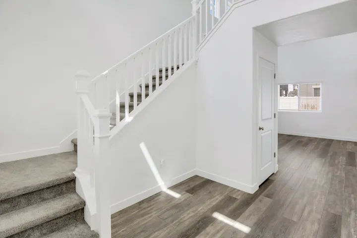 Staircase with white railing and carpeted treads