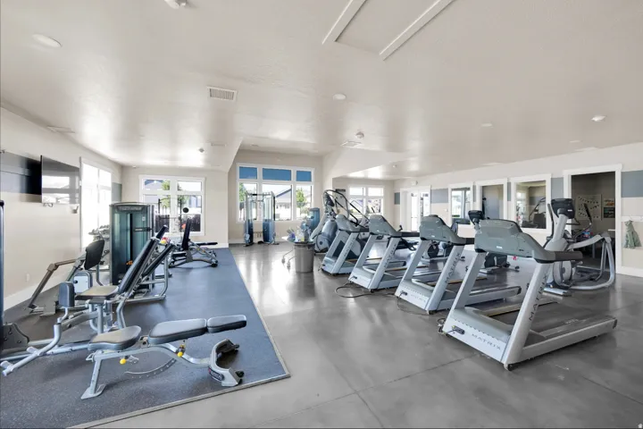Dedicated fitness area featuring multiple treadmills, weight benches, and cardio equipment