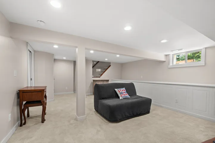 Finished lower level with recessed lighting, light-toned carpeting, and extensive wainscoting
