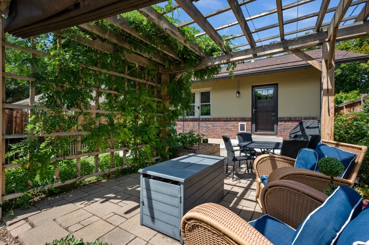 Paved patio with an overhead wooden pergola