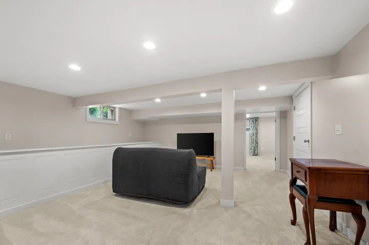 Recessed lighting, painted walls, carpet flooring, and a white paneled accent wall