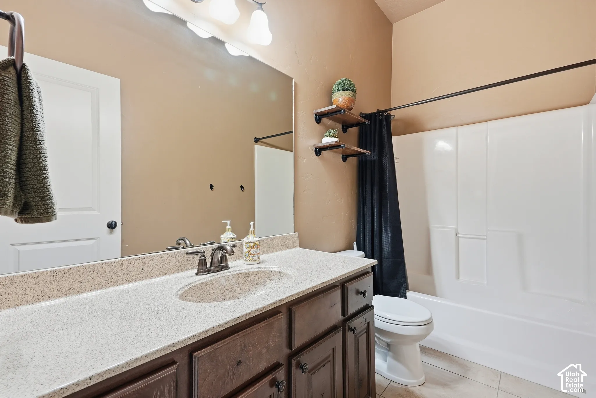 Integrated vanity with a single basin, dark wood-finish cabinetry, and a light-toned countertop