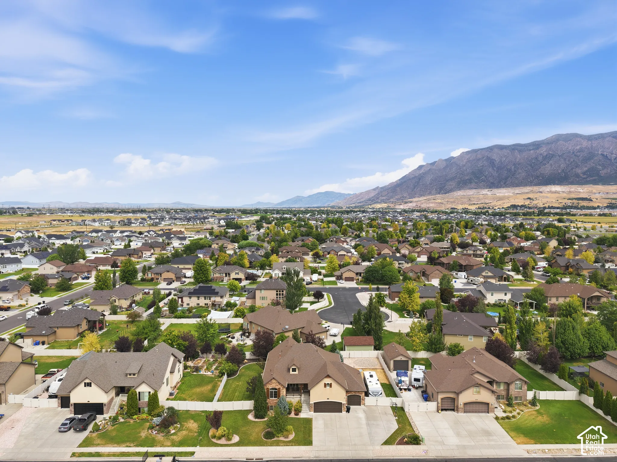 Residential community with varied architectural styles, mature landscaping, and mountain scenery
