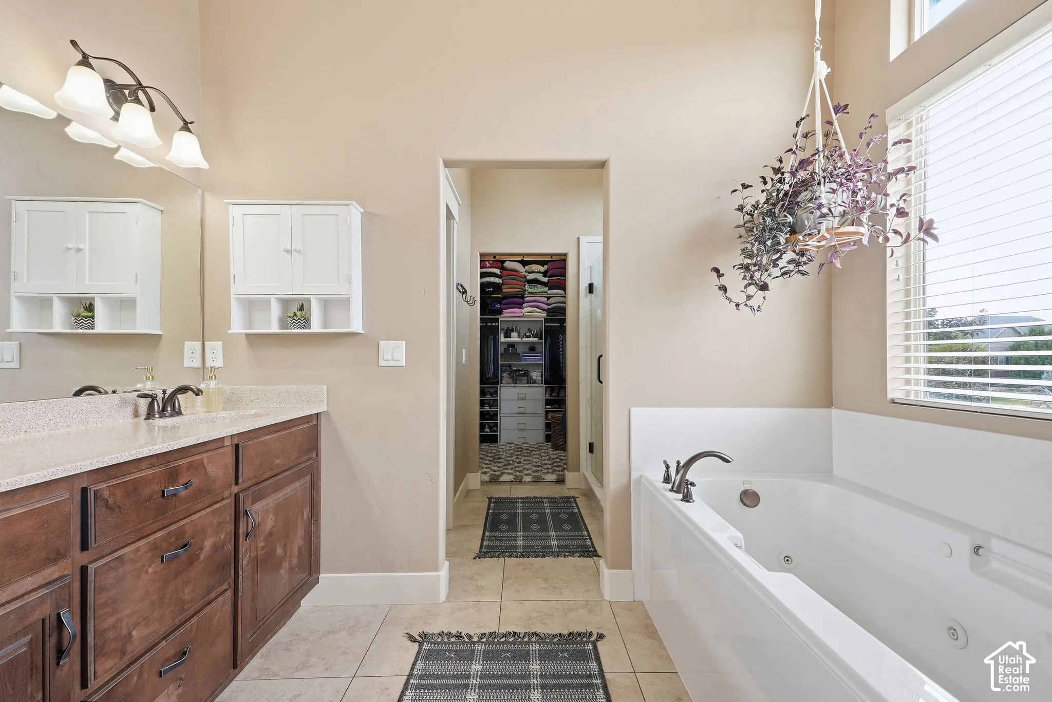 Dual wood-finish vanity with countertop, built-in storage cabinets, and an integrated soaking tub