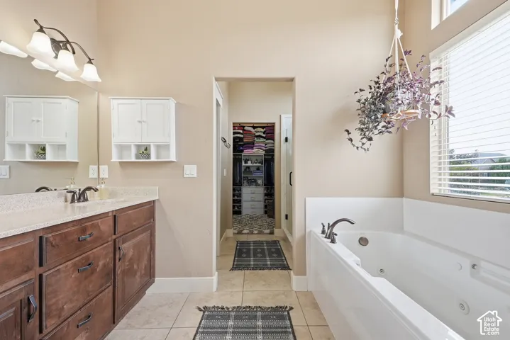 Dual wood-finish vanity with countertop, built-in storage cabinets, and an integrated soaking tub
