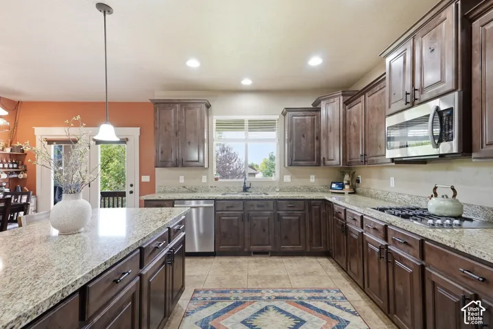 Kitchen featuring wood-finish cabinetry, granite countertops, stainless steel appliances, and recessed lighting