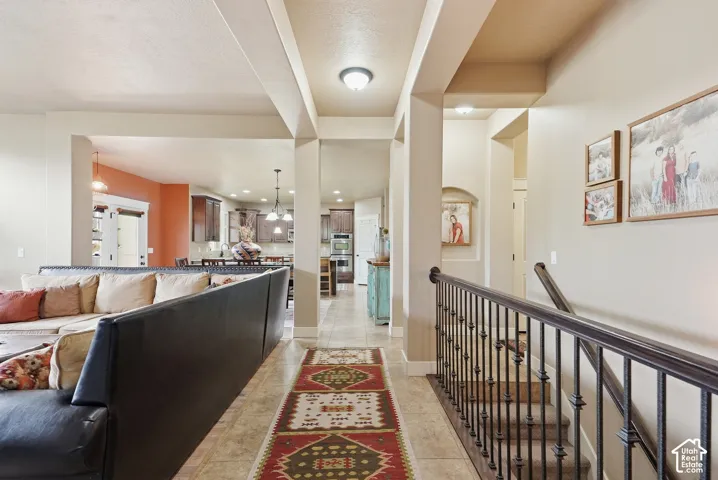 Open-concept layout with recessed lighting, tile flooring, and a wrought iron staircase railing