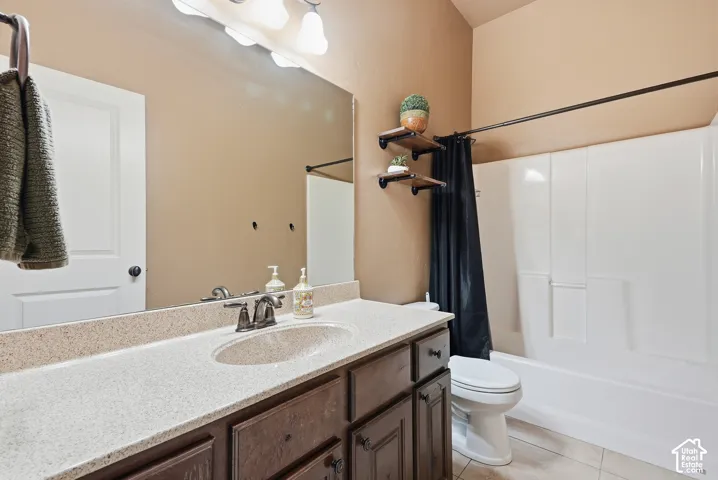 Integrated vanity with a single basin, dark wood-finish cabinetry, and a light-toned countertop