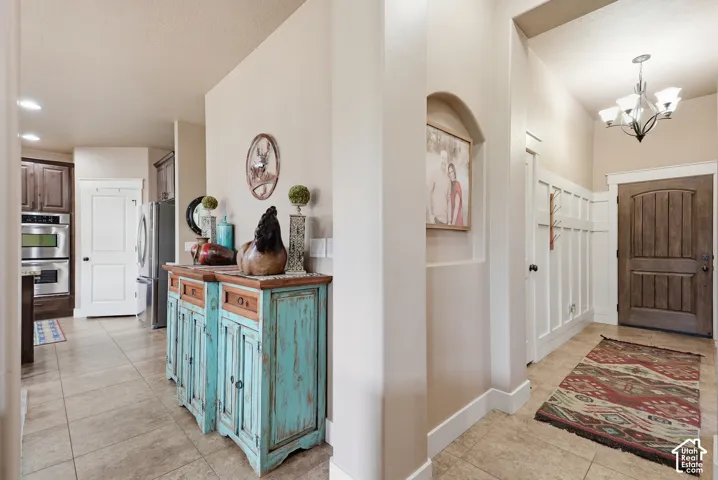 Wood-finish entry door, board and batten wall paneling, and tile flooring