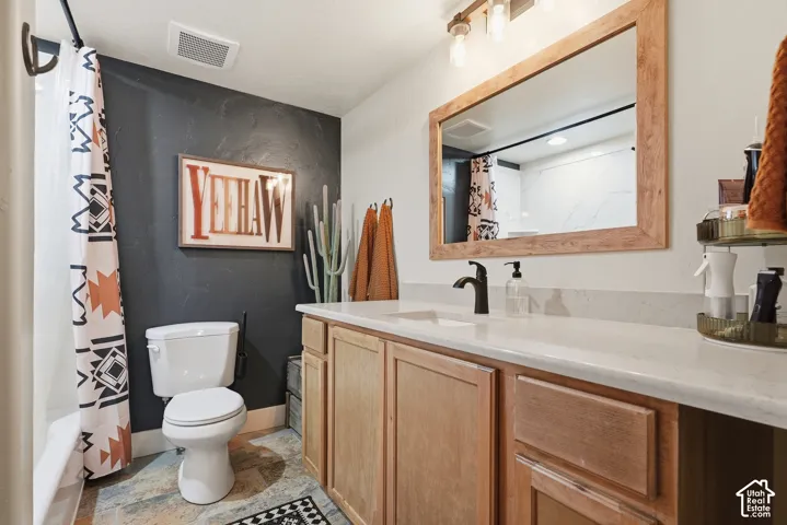Wood-finish vanity with a light-toned countertop, integrated sink, and matte black faucet