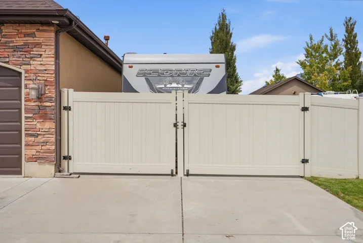 Double-gate entry with privacy fencing and concrete paving