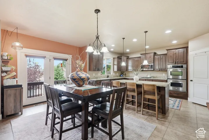 Spacious kitchen with wood cabinetry, stainless steel double ovens, a large island with bar seating, and granite countertops