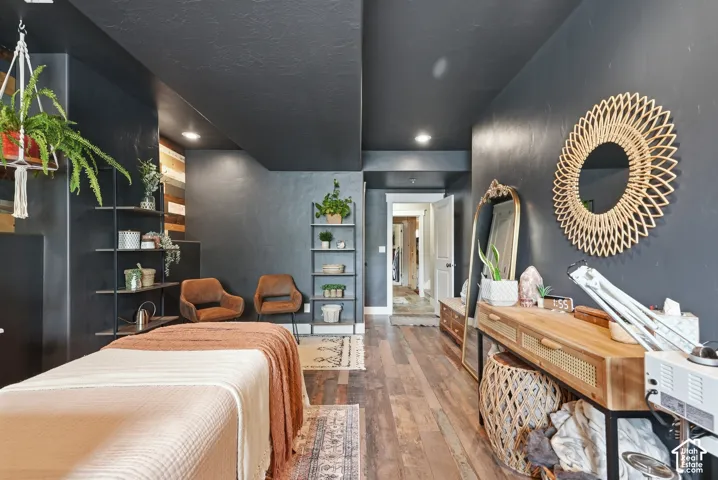 Wood-finish flooring, recessed lighting, built-in shelving, and dark-toned walls