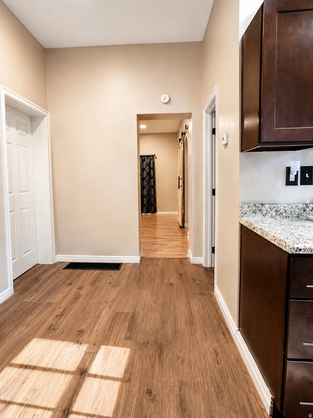 Wood-finish flooring throughout, complemented by dark wood cabinetry and a speckled countertop