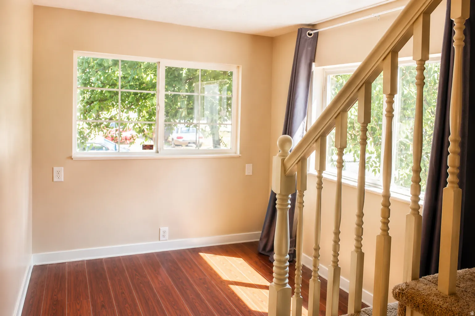 Hardwood-look flooring, light-toned wall paint, white trim, and a classic wood banister