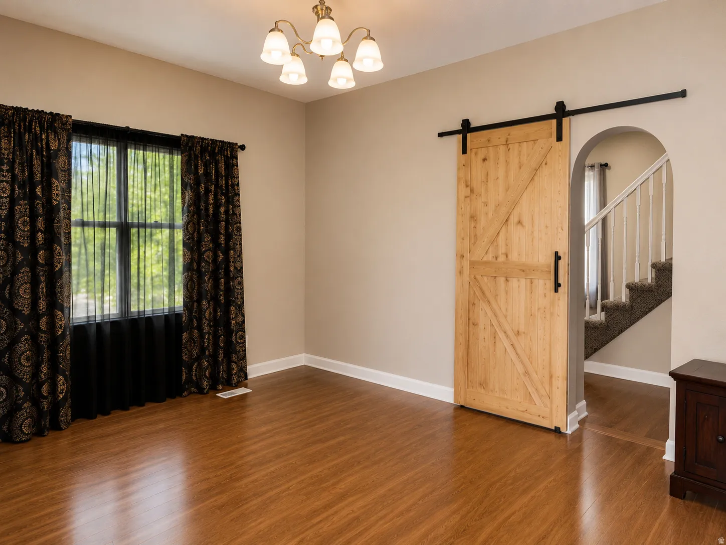 Wood-finish flooring throughout, complemented by a natural wood barn door with black hardware