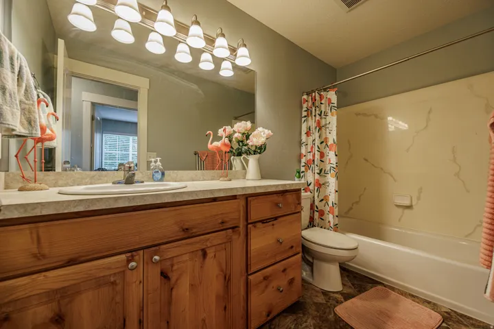 Vanity with wood-finish cabinetry, integrated sink, and laminate countertop