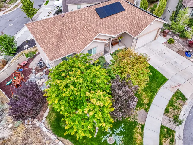 Single-family residence with an attached garage, solar panels, and a concrete driveway