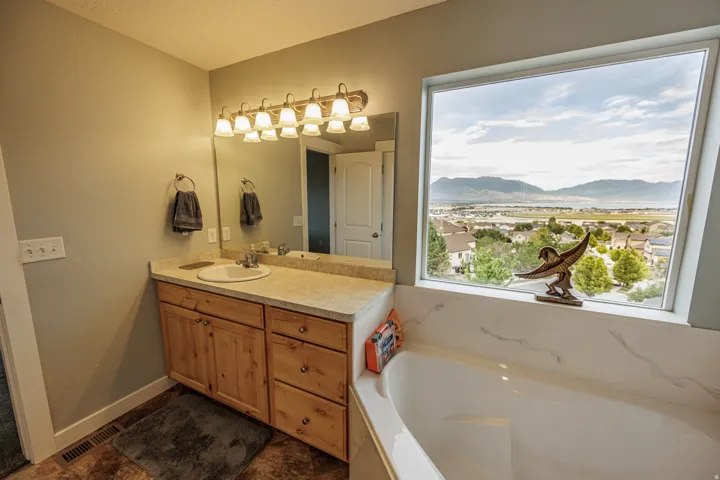 Single vanity with a wood-finish cabinet and a light-toned countertop